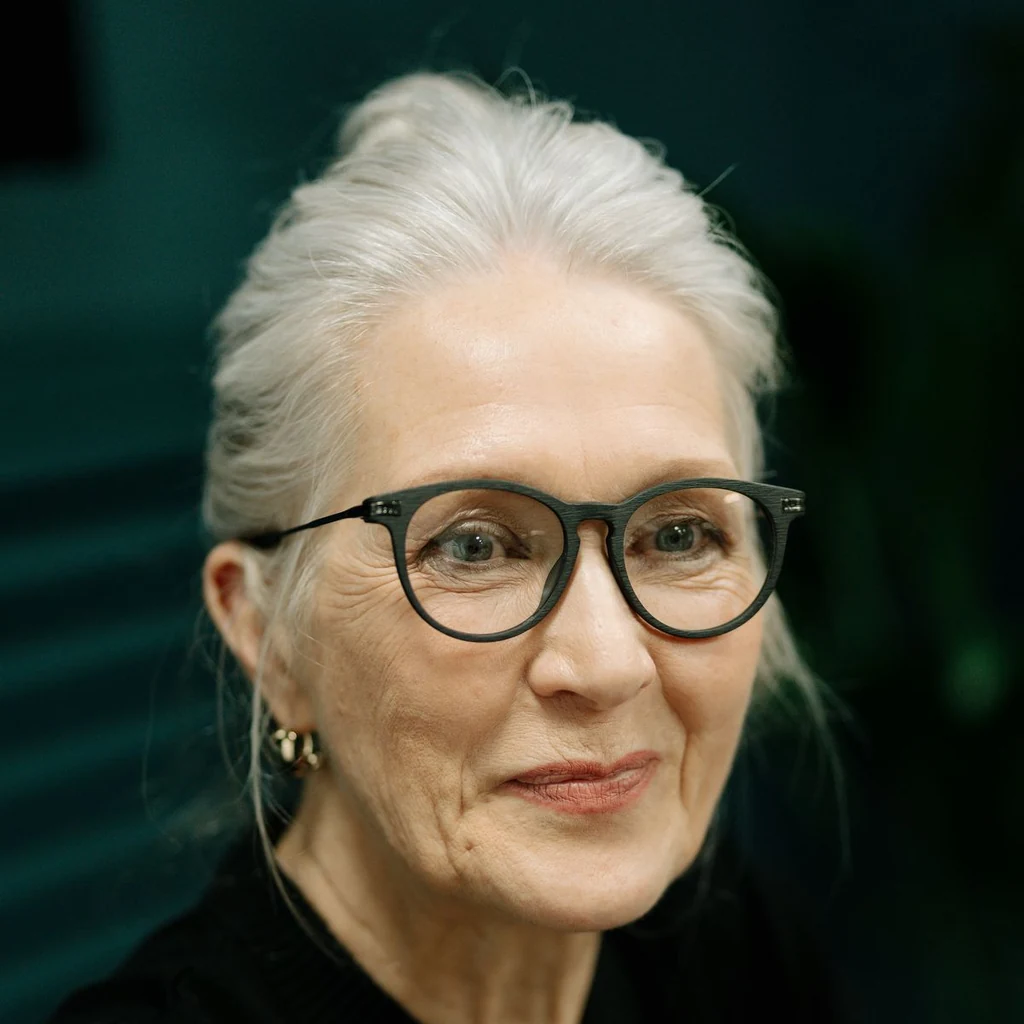 Woman over 60 with a messy silver pixie haircut and long sweeping top layers