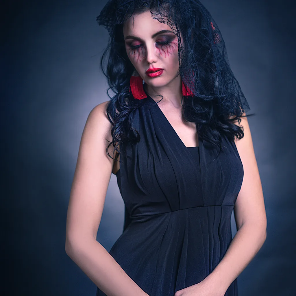 Woman in a black dress with dark gothic makeup, a Wednesday Addams inspired last minute costume