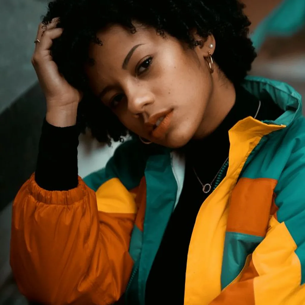 Woman in a neon colour-block windbreaker jacket, bold 80s street style outfit