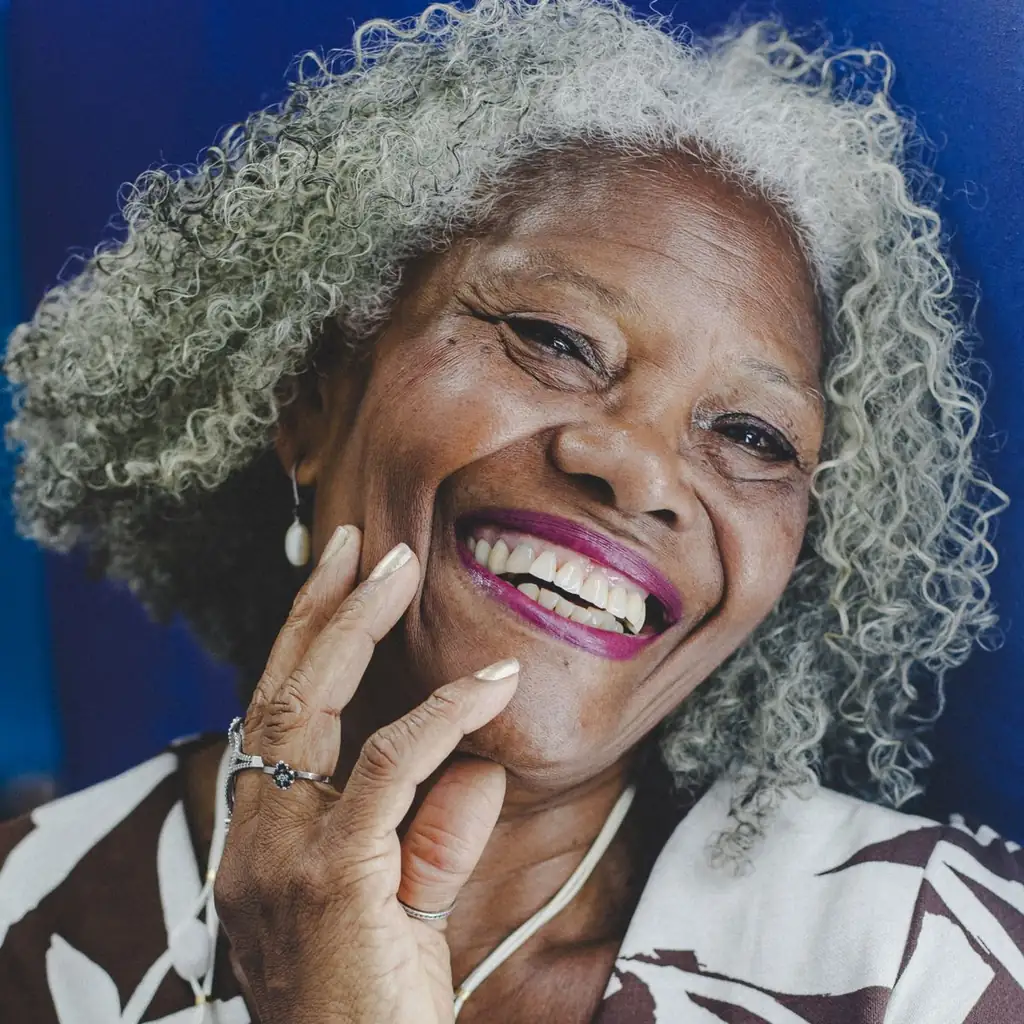 Woman over 60 with soft messy natural curls and silver highlights