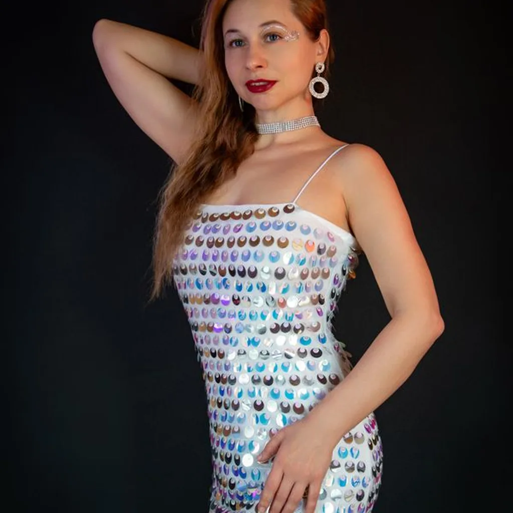 Woman in a silver sequin dress with glamorous earrings, Dynasty style 80s evening outfit