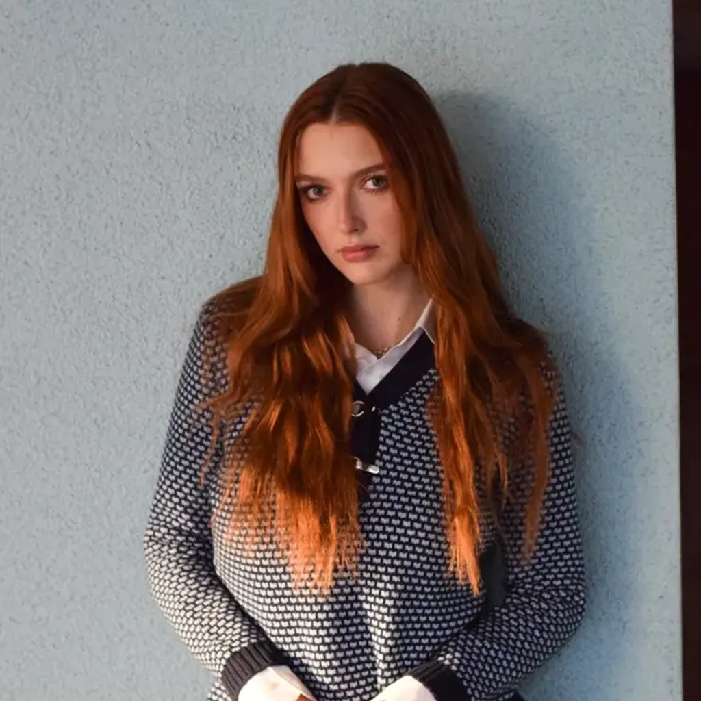 Woman in a knitted sweater over a collared shirt, preppy 80s style outfit