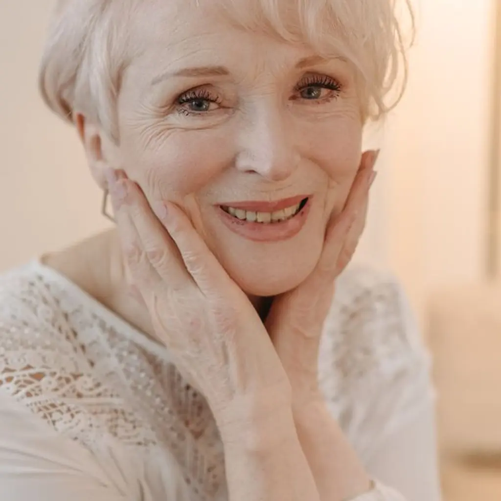 Soft curly gray layered haircut at shoulder length