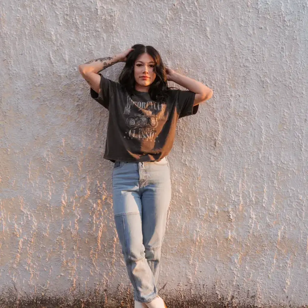 Woman in high-waist mom jeans and a vintage graphic t-shirt, casual 80s outfit