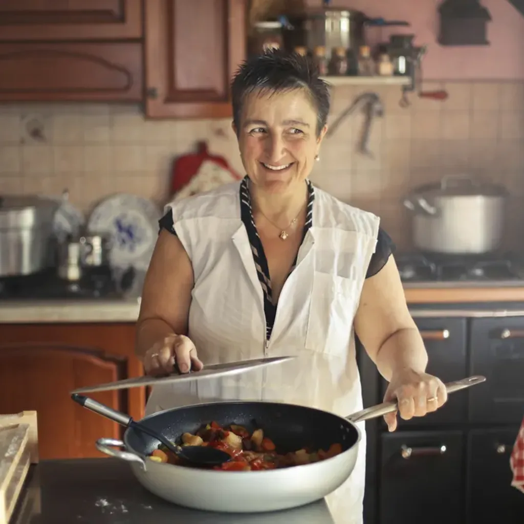 Smiling cook in a home kitchen holding a frying pan, an easy DIY chef costume