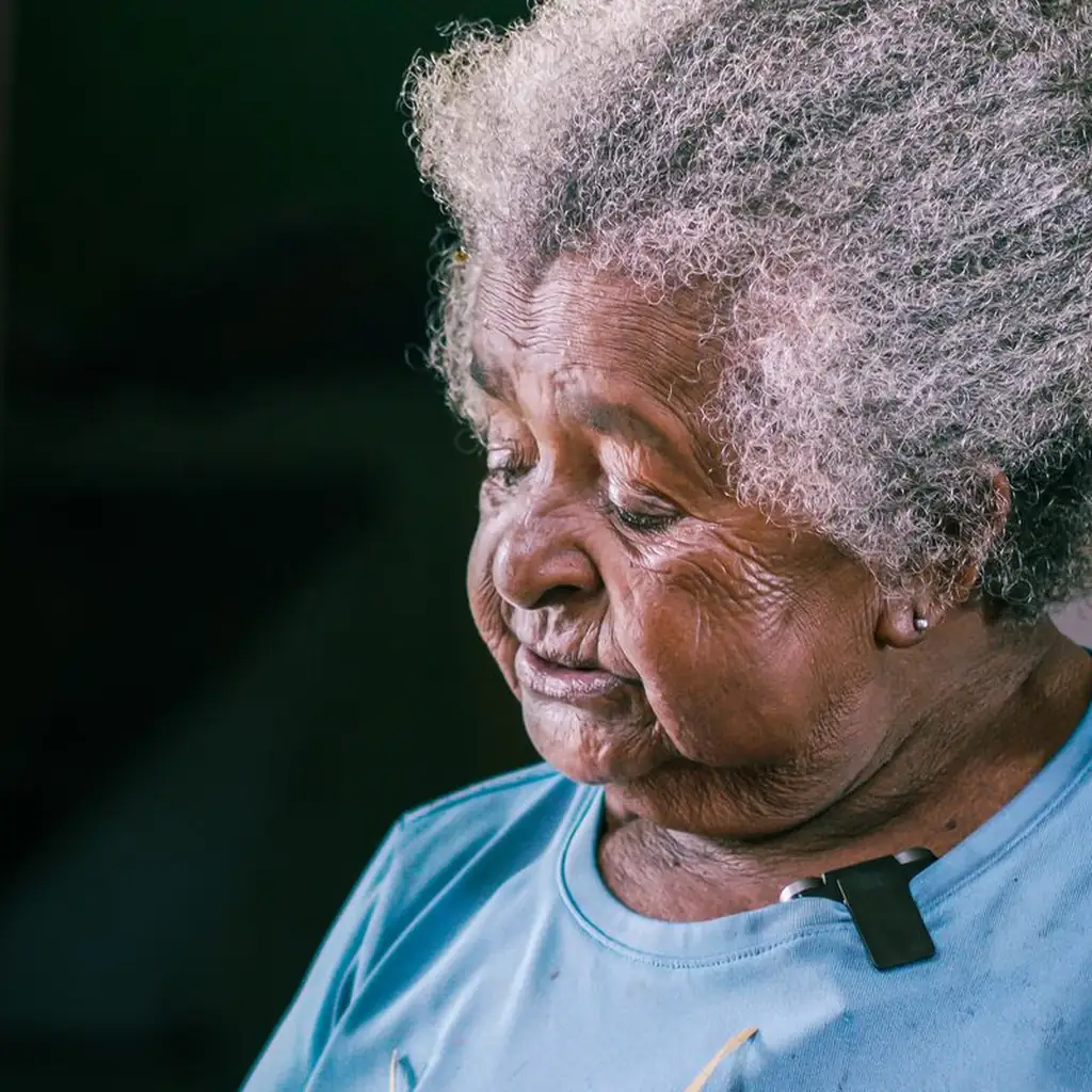 Curly messy pixie haircut with silver curls on a joyful woman over 60