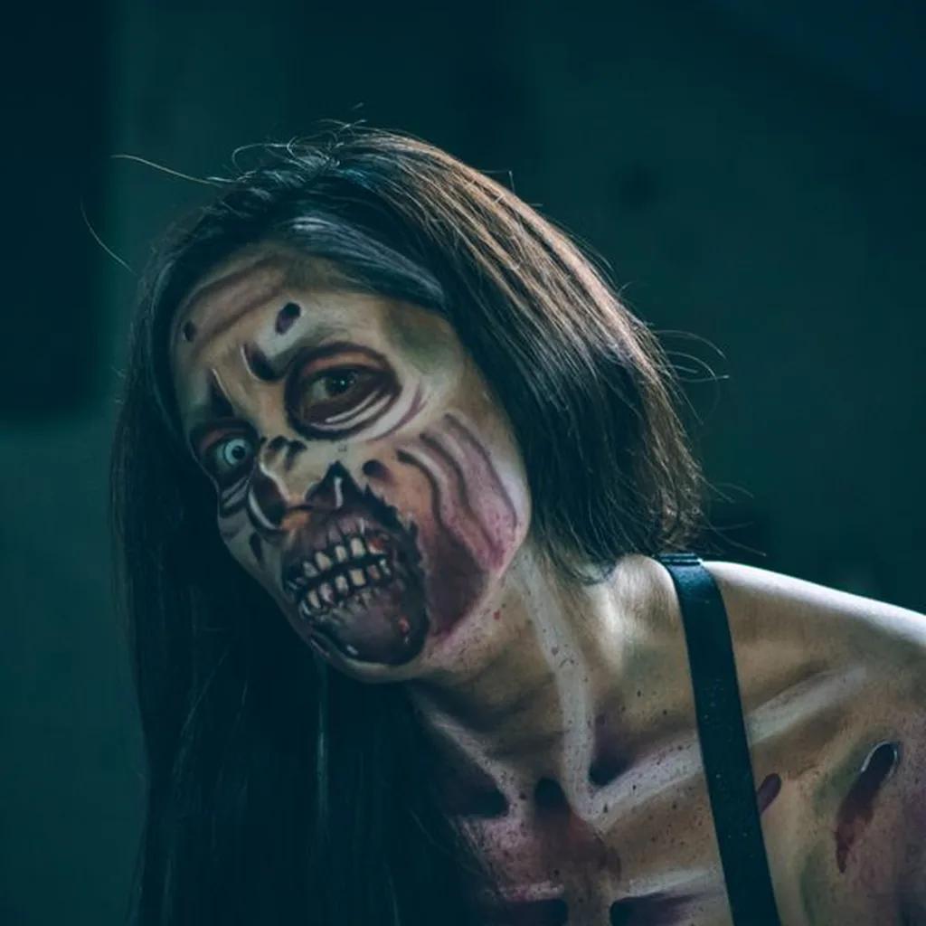 Woman with scary zombie face paint and Halloween makeup