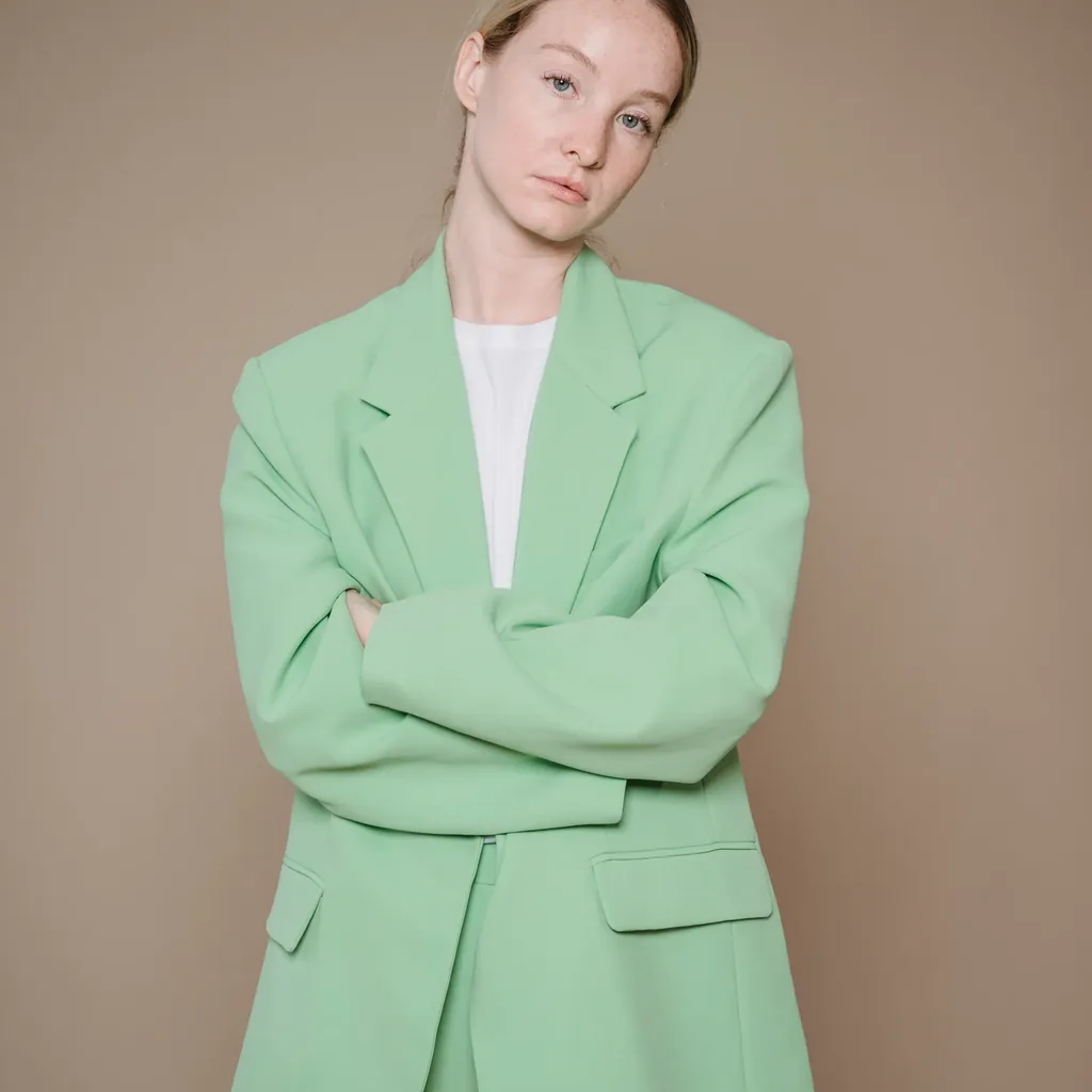 Woman in a pastel mint oversized suit, Miami Vice inspired 80s pastel outfit